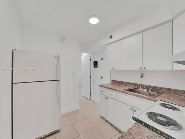 a kitchen with stainless steel appliances granite countertop white refrigerator stove and white cabinets