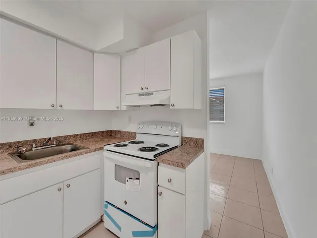 a kitchen with granite countertop white cabinets and white appliances