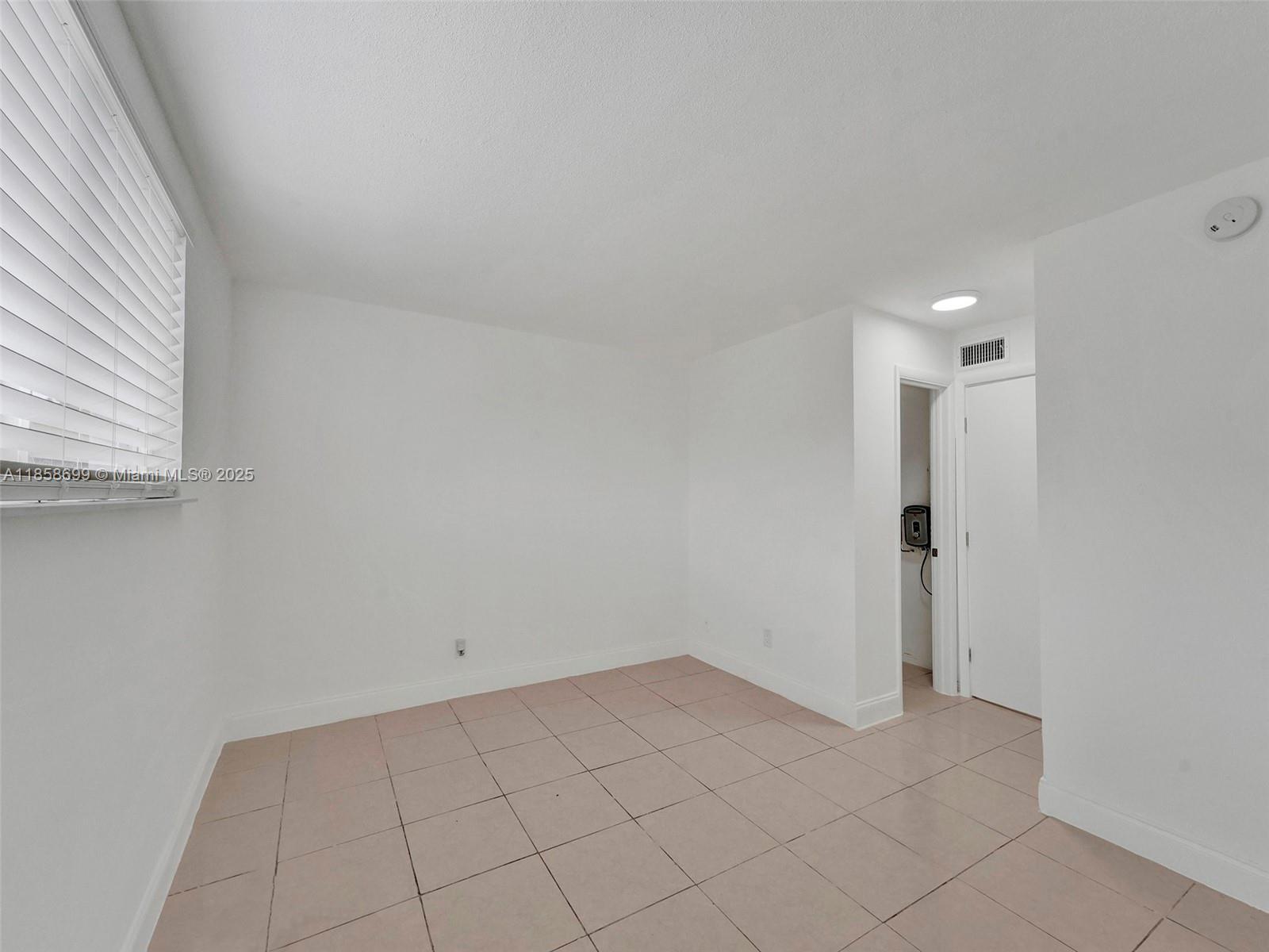 14190 West Dixie Highway, Unit 11 North Miami, FL 33161 - Photo 5 of 21 a view of an empty room and window