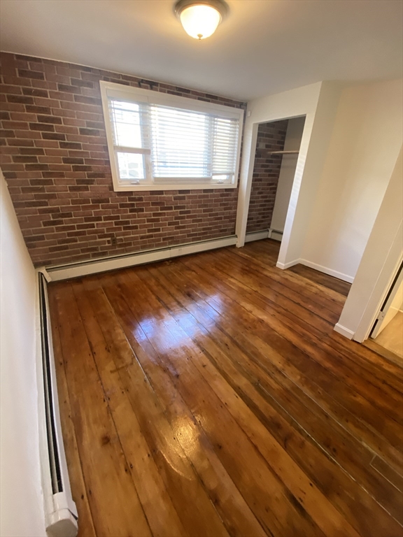 51 School Street, Unit 1 Boston, MA 02129 - Photo 6 of 11 a view of an empty room with wooden floor and a window