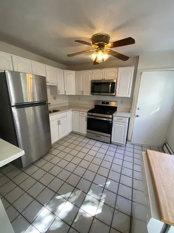 a kitchen with stainless steel appliances granite countertop a sink a stove a refrigerator cabinets and chairs
