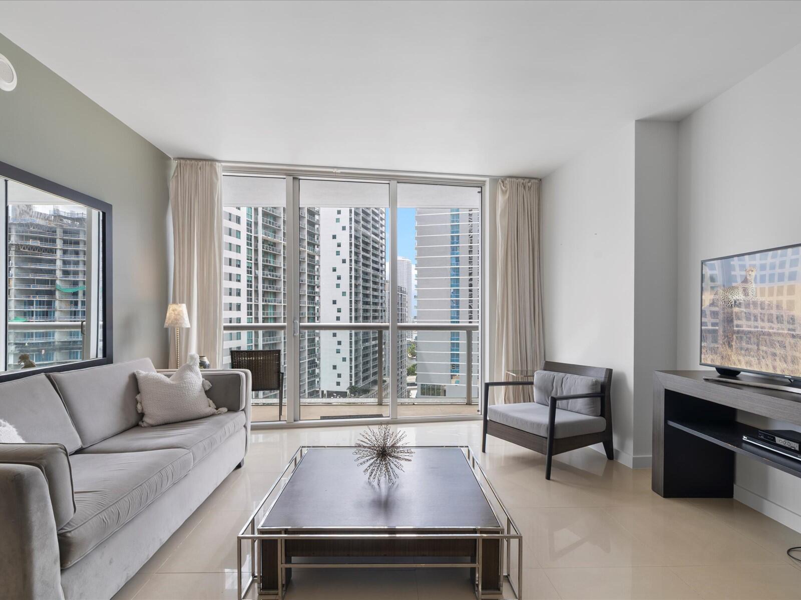 485 Brickell Avenue, Unit 2107 Miami, FL 33131 - Photo 1 of 18 a living room with furniture and a large window