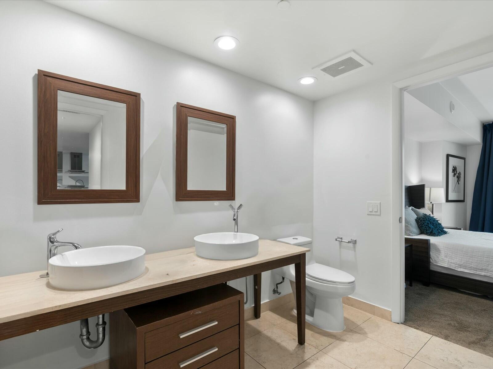 485 Brickell Avenue, Unit 2107 Miami, FL 33131 - Photo 9 of 18 a bathroom with a granite countertop sink a toilet and a mirror