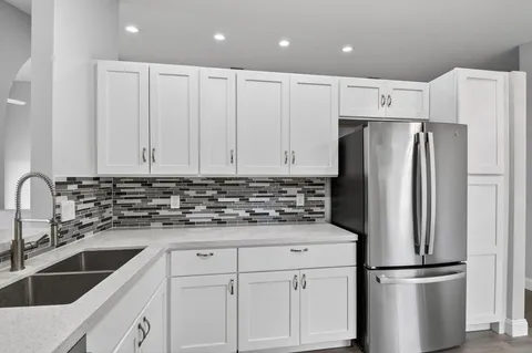 a kitchen with stainless steel appliances granite countertop a refrigerator and a stove top oven