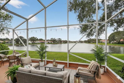 a view of a house with a large window and a yard with large trees