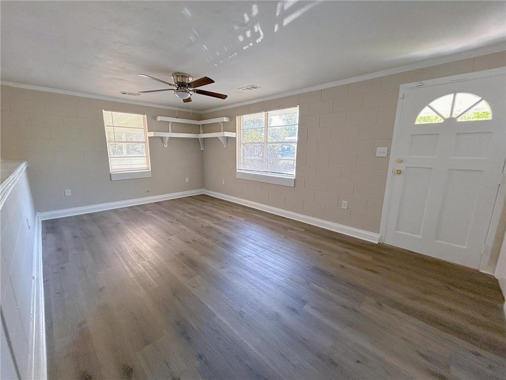 271 Rehoboth Road Griffin, GA 30223 - Photo 5 of 9 an empty room with wooden floor chandelier fan and windows