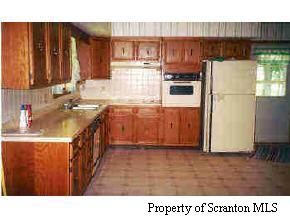 a kitchen with a refrigerator a sink and wooden cabinets