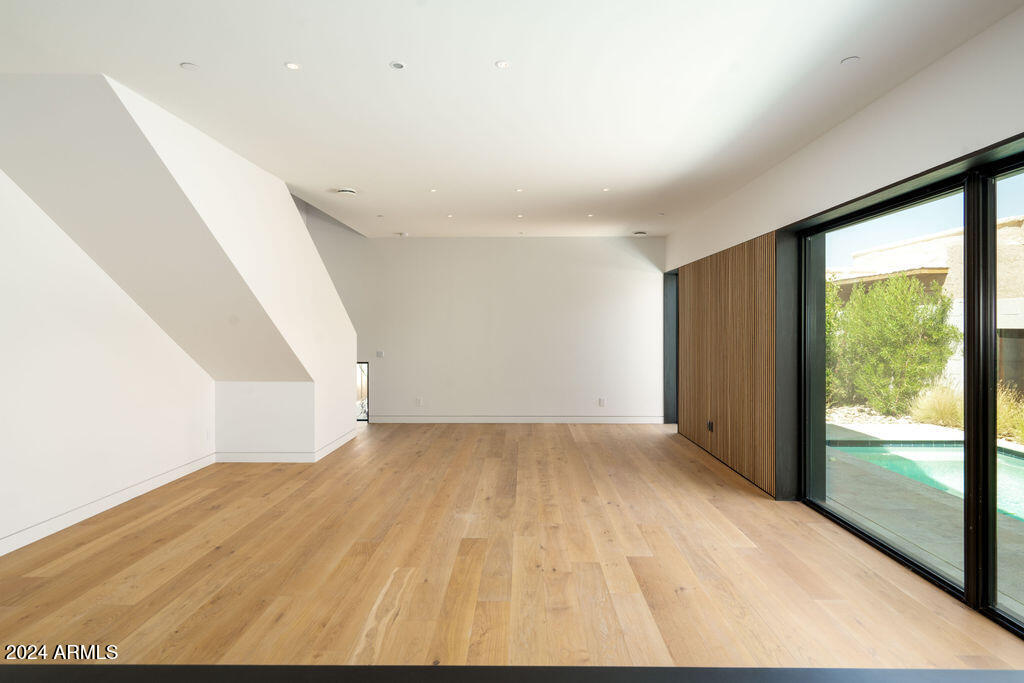 1740 East Ocotillo Road, Unit 4 Phoenix, AZ 85016 - Photo 5 of 20 an empty room with wooden floor and windows