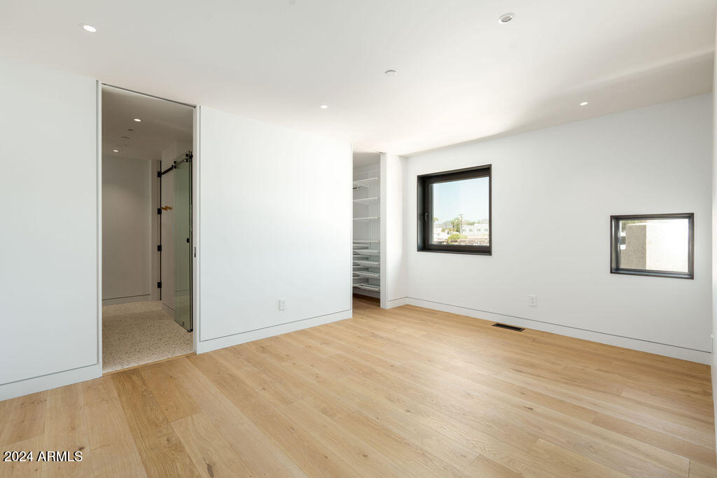 1740 East Ocotillo Road, Unit 4 Phoenix, AZ 85016 - Photo 10 of 20 an empty room with wooden floor and windows