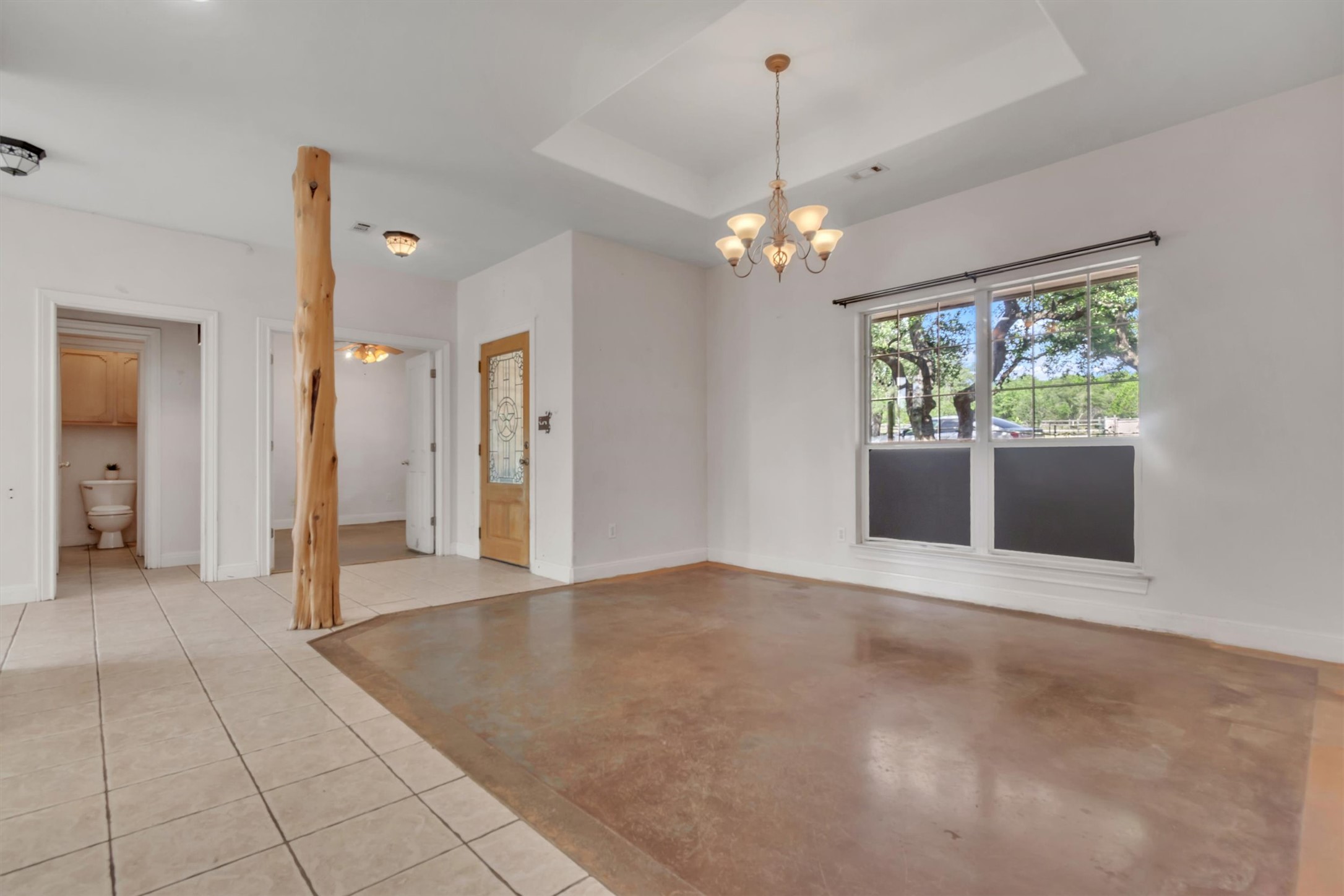 1120 Meadow Ridge Drive Austin, TX 78737 - Photo 8 of 40 A rustic wood column anchors this versatile interior, featuring a detailed entry door and large picture window.