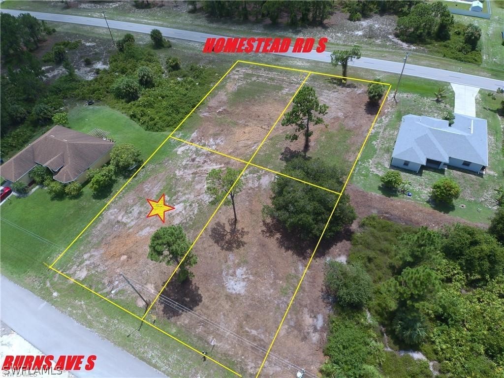 749 Homestead Road South Lehigh Acres, FL 33974 - Photo 2 of 2 a aerial view of a house with a yard and lake