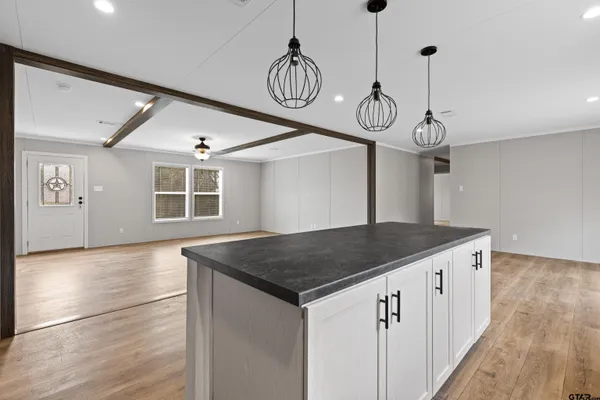 a kitchen with granite countertop stainless steel appliances a sink and a wooden floor