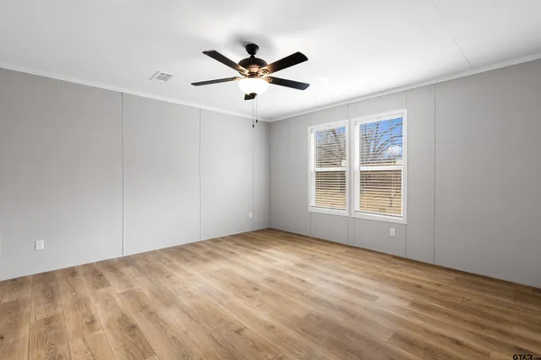 a view of empty room with wooden floor