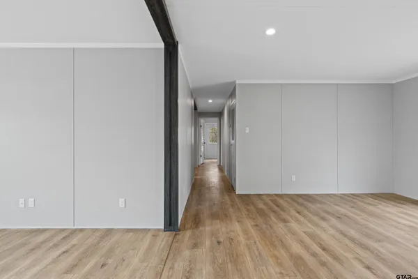 a view of an empty room with window and ceiling fan