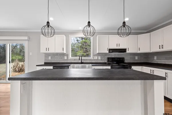 a kitchen with stainless steel appliances granite countertop a sink a window appliances and cabinets