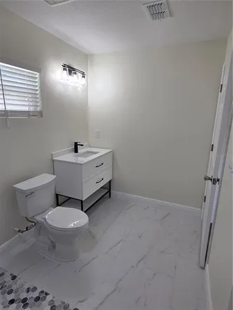 a white toilet sitting next to a bathroom sink