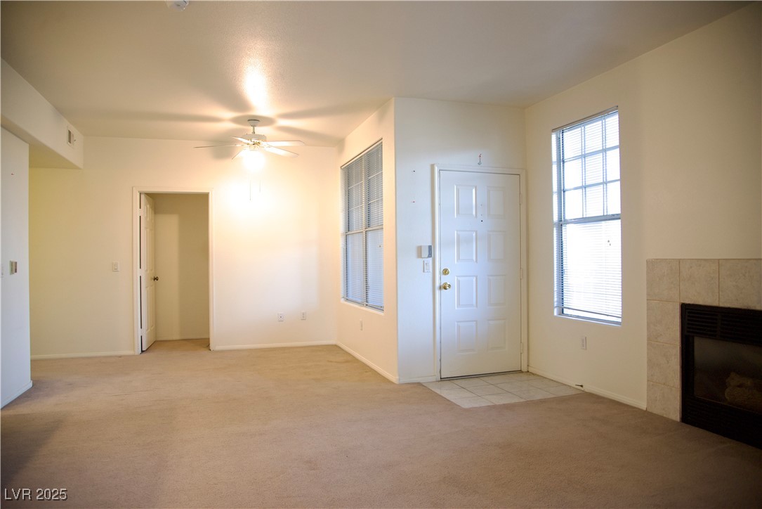 8555 West Russell Road, Unit 1078 Las Vegas, NV 89113 - Photo 13 of 34 Entrance foyer with a tile fireplace, light colored carpet, and ceiling fan