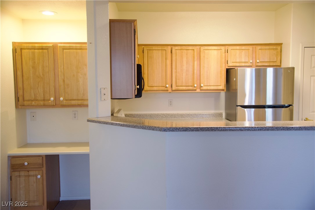 8555 West Russell Road, Unit 1078 Las Vegas, NV 89113 - Photo 20 of 34 Kitchen featuring freestanding refrigerator, light stone countertops, and light brown cabinets