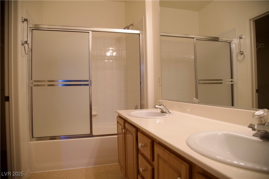 8555 West Russell Road, Unit 1078 Las Vegas, NV 89113 - Photo 23 of 34 Full bathroom featuring double vanity, combined bath / shower with glass door, and light tile patterned floors