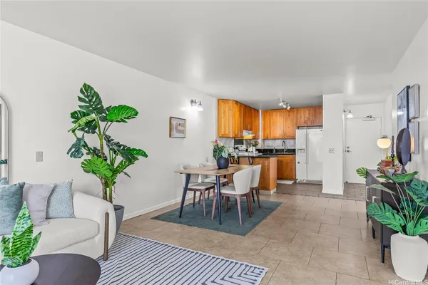 a living room with furniture a potted plant and a large window