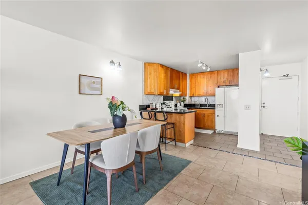 a kitchen with stainless steel appliances kitchen island granite countertop a refrigerator a stove a microwave oven with a dining table and chairs