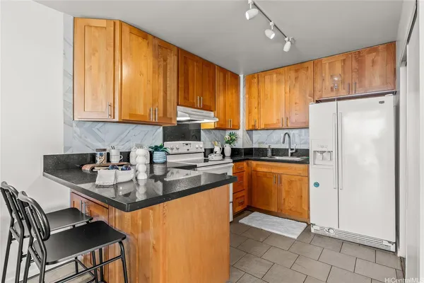 a kitchen with stainless steel appliances granite countertop a stove refrigerator sink and cabinets