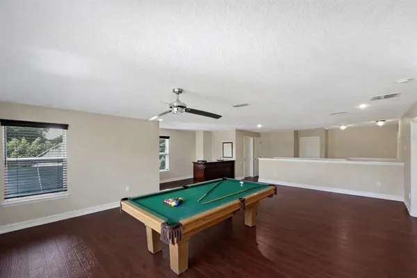 a room with pool table and windows