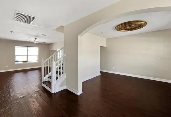 an empty room with wooden floor and windows