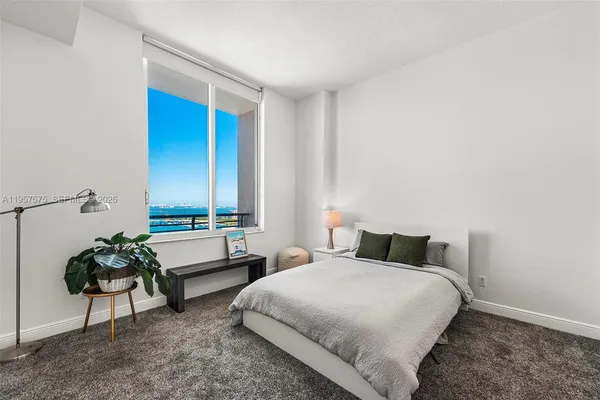 a bedroom with a bed and a potted plant