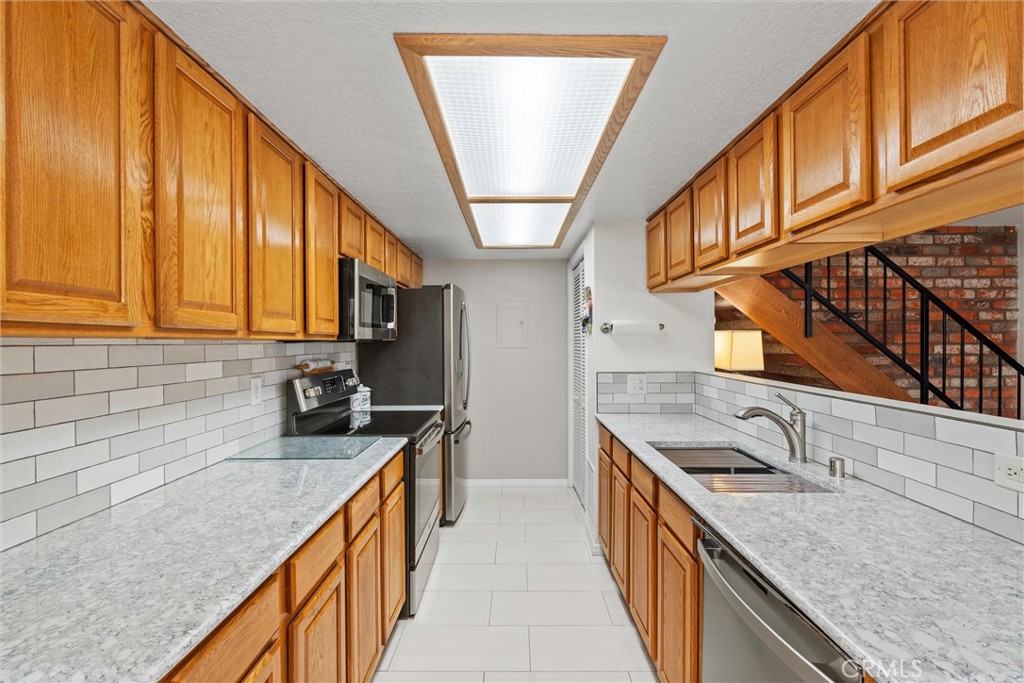 20800 Plum Canyon Road Saugus, CA 91350 - Photo 9 of 26 a kitchen with stainless steel appliances granite countertop a sink a stove and a wooden floors