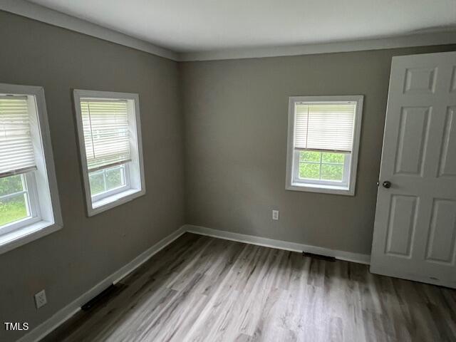 7710 Leasburg Road Roxboro, NC 27574 - Photo 11 of 24 a view of an empty room with wooden floor and a window