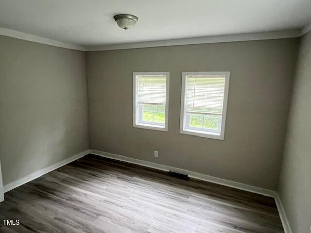 7710 Leasburg Road Roxboro, NC 27574 - Photo 12 of 24 a view of an empty room with wooden floor and a window