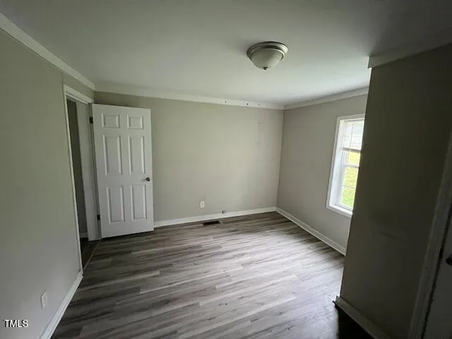 a view of a room with wooden floor and a bathroom