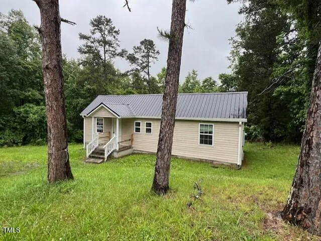a view of a house with a yard and sitting area