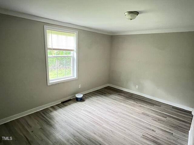 7710 Leasburg Road Roxboro, NC 27574 - Photo 10 of 24 an empty room with wooden floor and windows