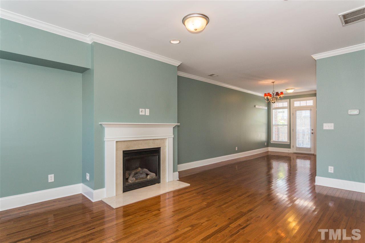 610 Highpark Lane Raleigh, NC 27608 - Photo 4 of 25 a view of an empty room with wooden floor and a fireplace