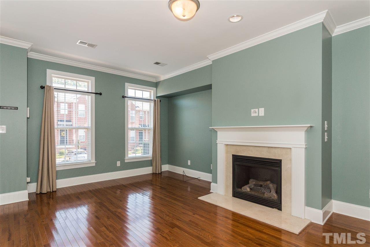 610 Highpark Lane Raleigh, NC 27608 - Photo 5 of 25 a view of an empty room with wooden floor fireplace and a window