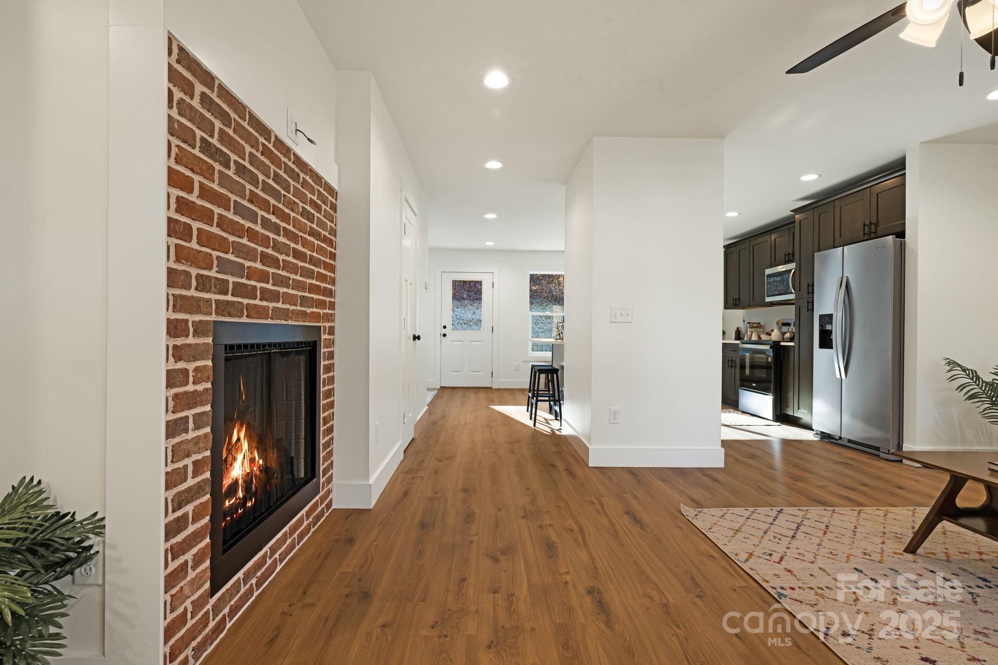 386 Holtzclaw Street Canton, NC 28716 - Photo 11 of 43 a view of a hallway with wooden floor and a fireplace