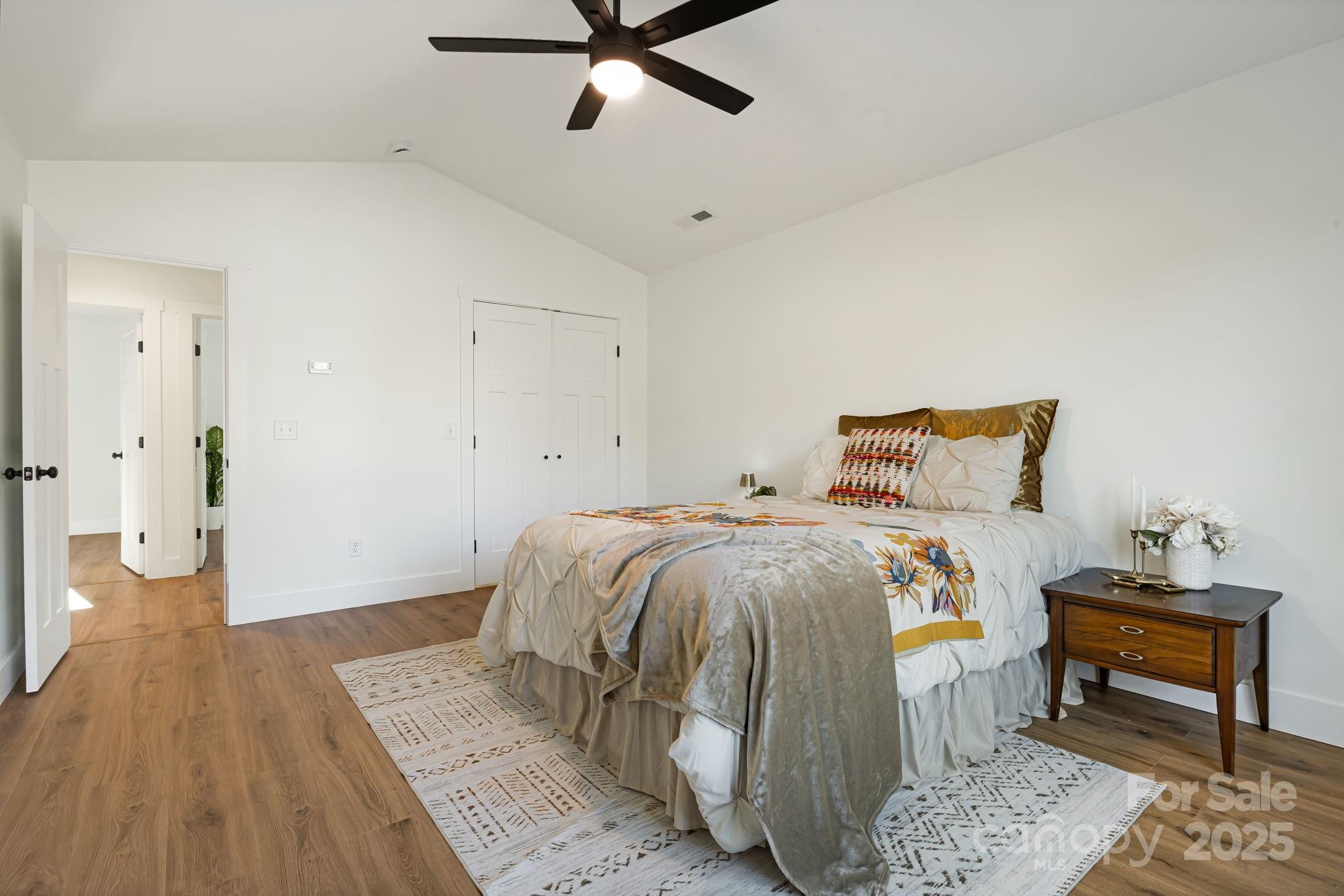 386 Holtzclaw Street Canton, NC 28716 - Photo 27 of 43 a bedroom with a bed and wooden floor