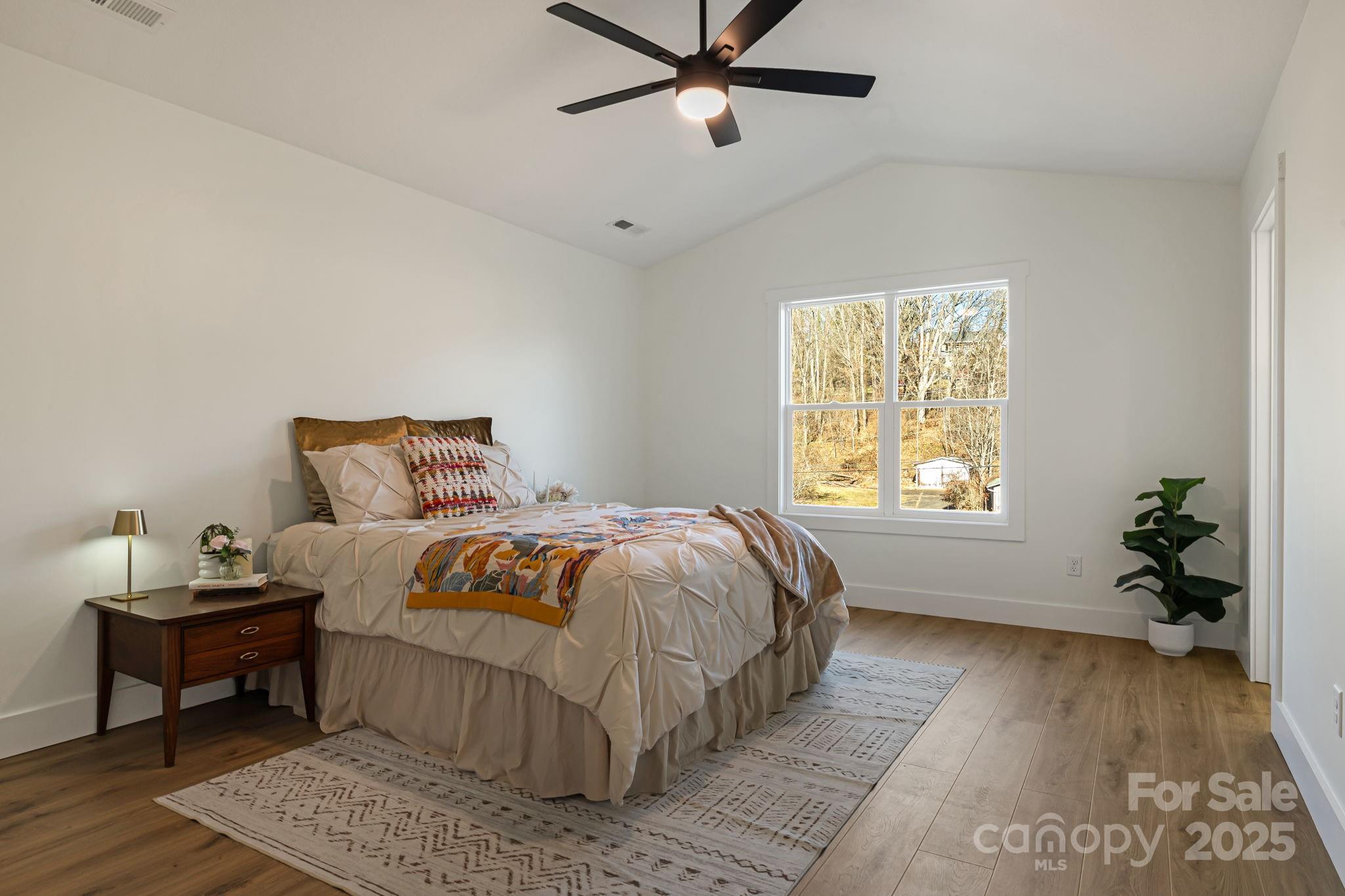 386 Holtzclaw Street Canton, NC 28716 - Photo 28 of 43 a bedroom with a bed and wooden floor