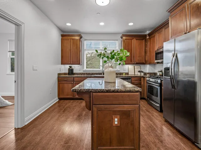 a kitchen with kitchen island stainless steel appliances a sink stove and refrigerator