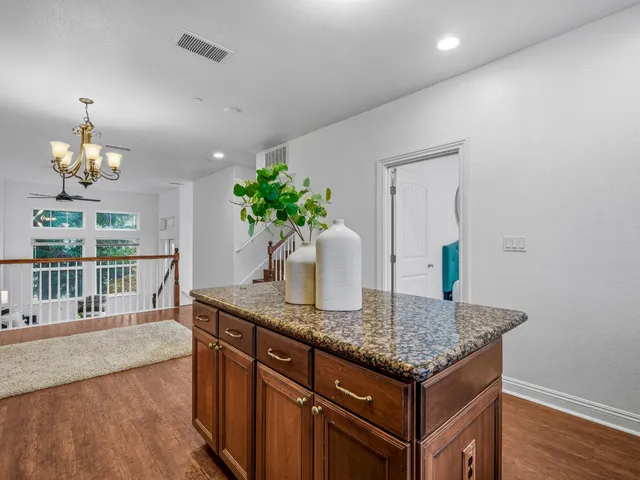 a kitchen with granite countertop kitchen island stainless steel appliances a table and chairs in it