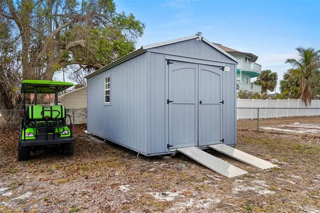 a backyard of a house with potted plants and large tree