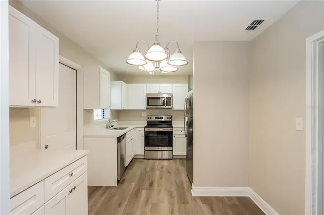 a kitchen with stainless steel appliances granite countertop a stove and cabinets