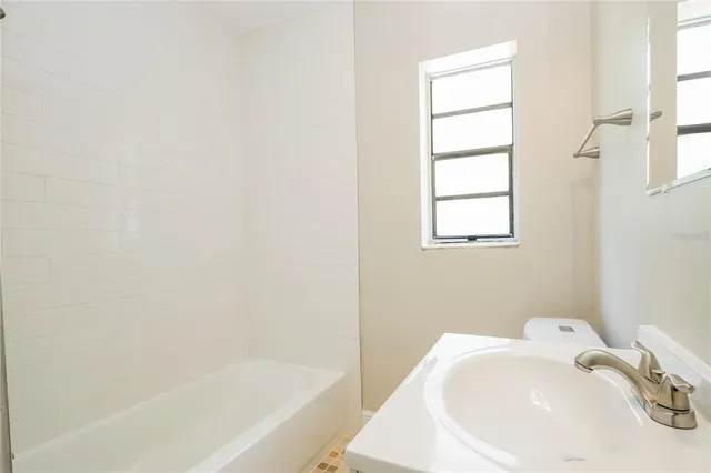 a white bath tub sitting next to a white sink