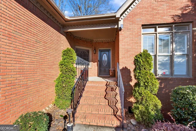 a view of a livingroom with a fireplace a chandelier and wooden floor