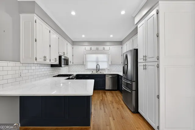 a kitchen with granite countertop white cabinets and stainless steel appliances