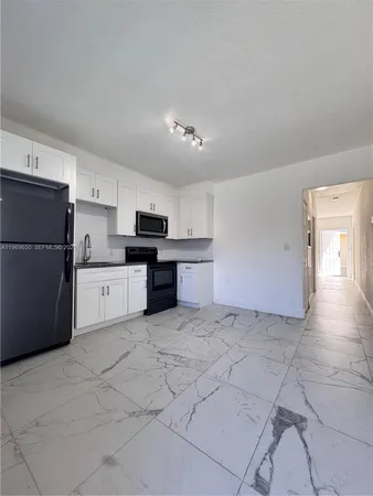 a kitchen with stainless steel appliances granite countertop a refrigerator sink and cabinets