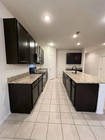 a view of kitchen with microwave and cabinets