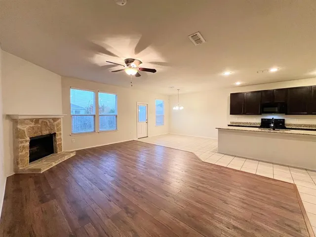 a kitchen with kitchen island granite countertop a stove top oven a sink a counter space and cabinets